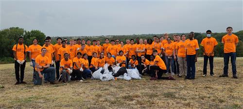 Studens in orange shirts with trash bags