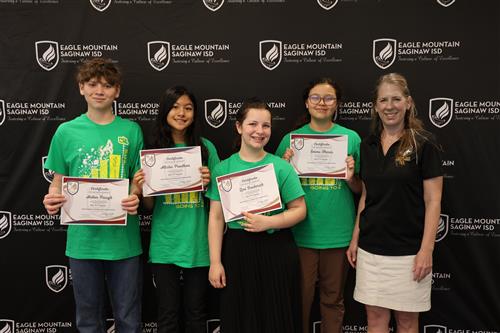 four students holding certificates and an adult woman