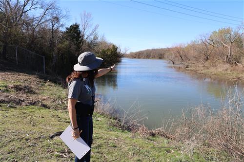 A woman points to a lake
