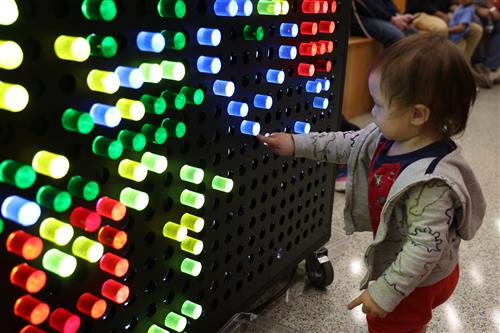 A boy touches a colorful light