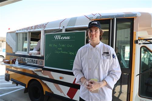student standing in front of a food truck