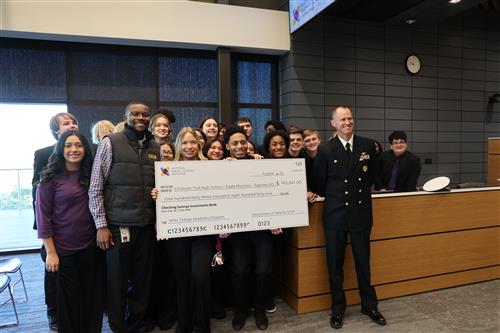 Students and officials holding a large ceremonial check