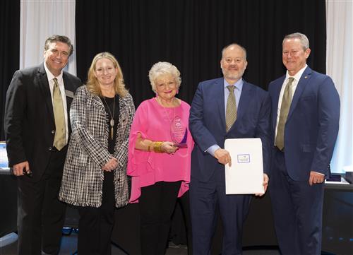 A group of people standing together holding an award