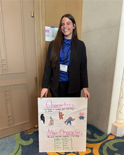 A girl in professional dress holding a bulletin board