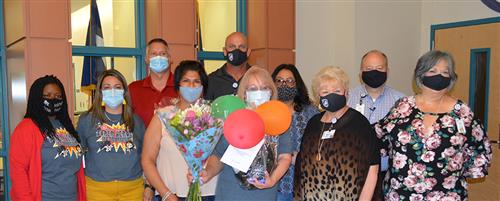 Photo of the auxiliary employee of the year and administrative leaders inside an elementary school