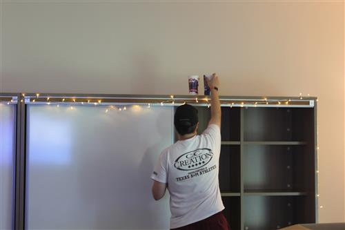 A man puts Texas rangers ups on a shelf