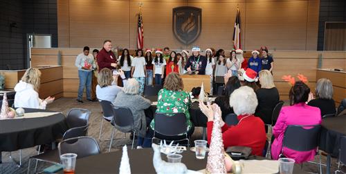 A group of people watches students perform