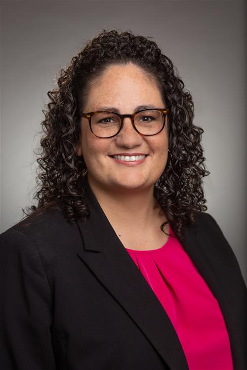 A woman with glasses smiling