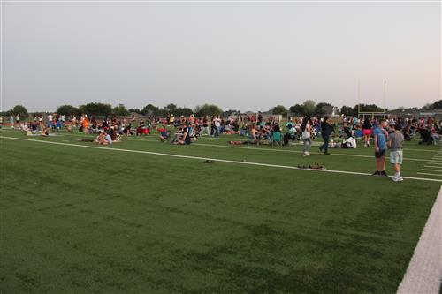 A large group of people sitting on a field
