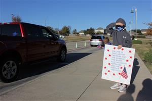A Student salutes a veteran  at Greenfield Elementary 