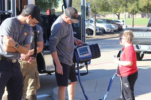 A student wears a heart rate monitor with firefighters