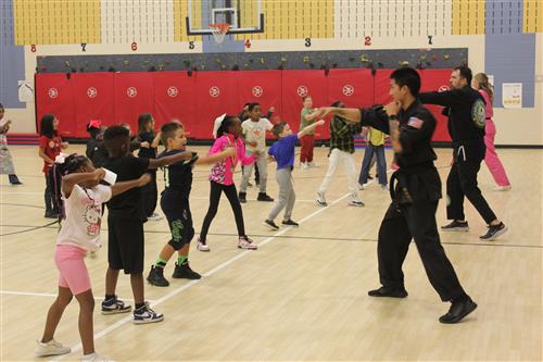 students to karate in a gymnasium
