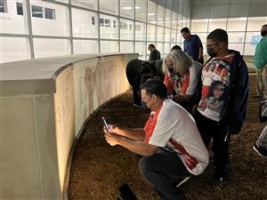 Attendees take photos of the names of their loved ones