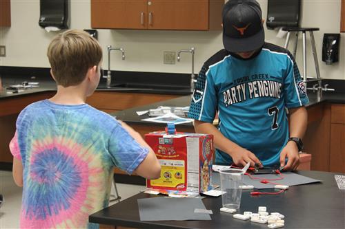 Two middle school age boys work on a science project