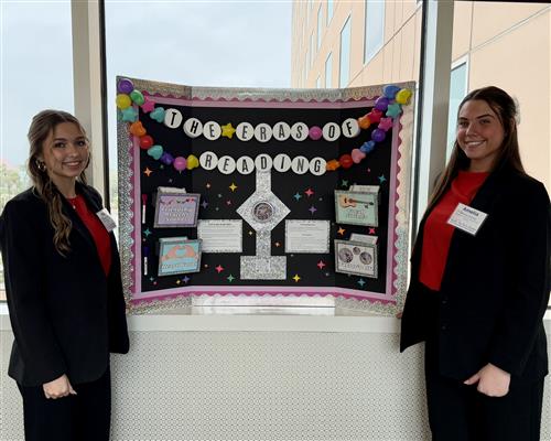Two girls by a bulletin board in professional dress