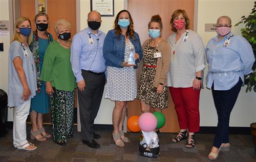 Photo of the paraprofessional of the year and administrative leaders inside an elementary 