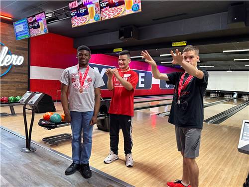 Special Olympians Celebrate while bowling, there are three of them
