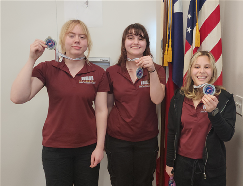 Three students hold up medals