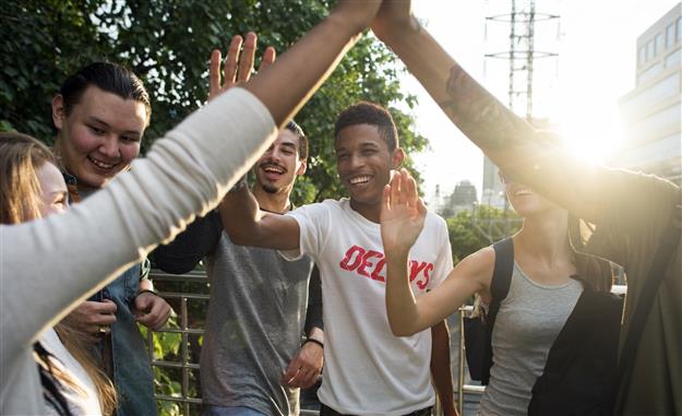 diverse group of kids high fiving each other