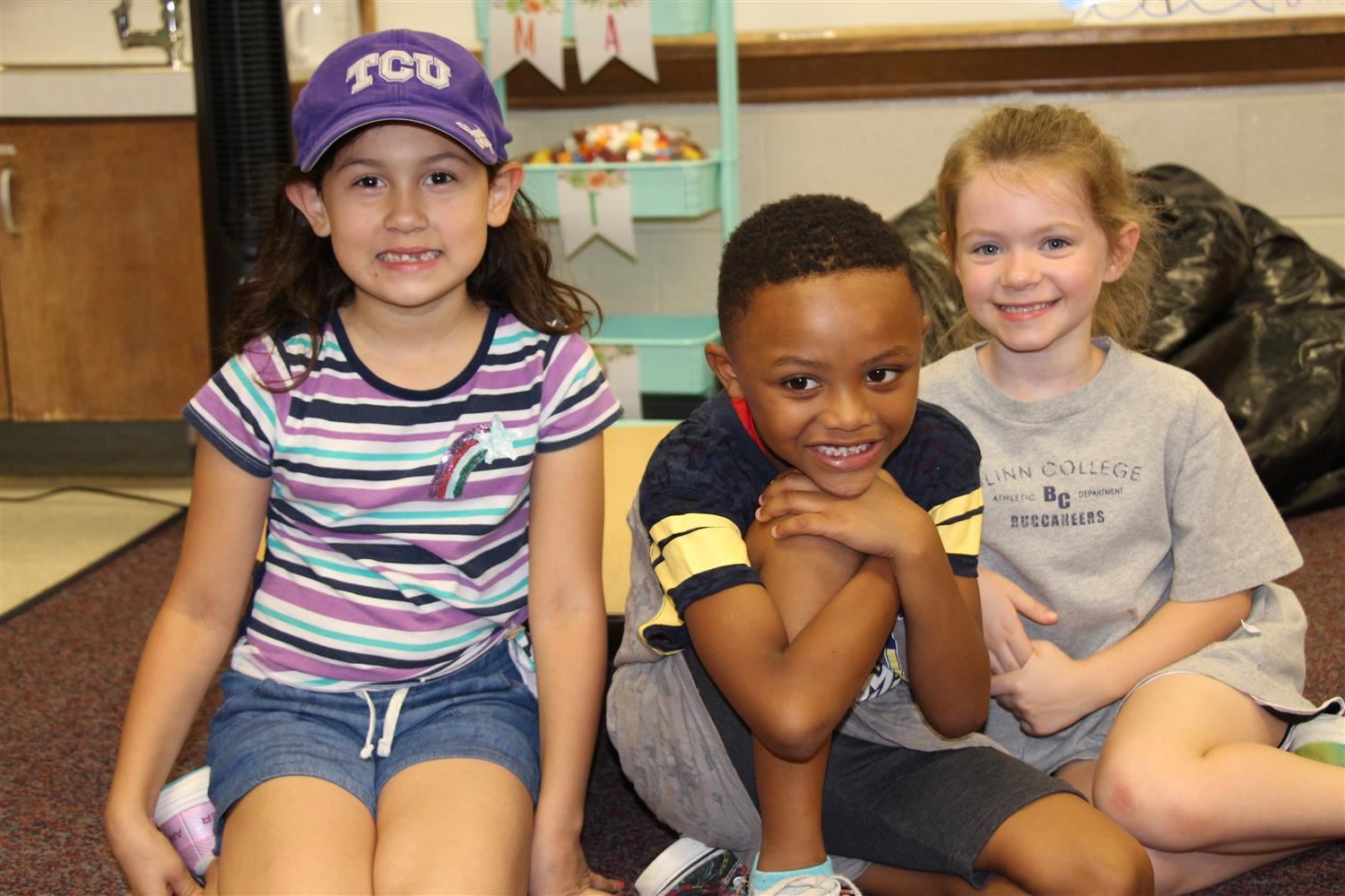 Elementary students sitting and smiling