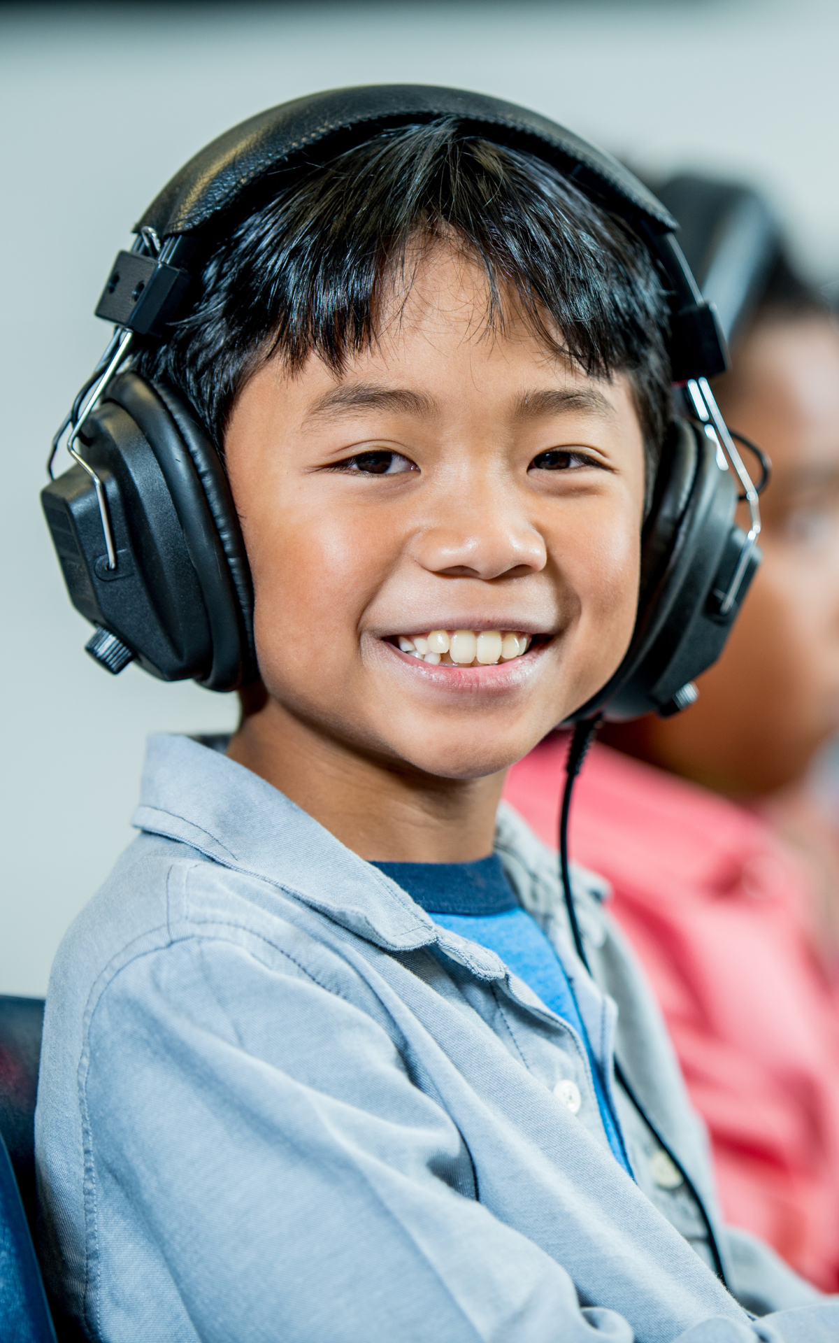 student with headphones in front of a computer