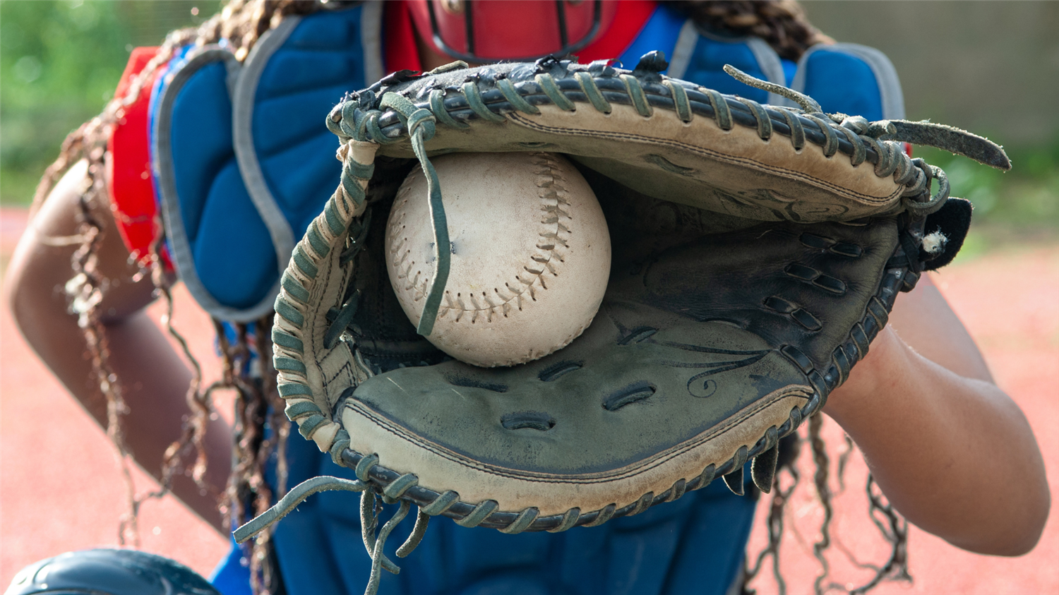 softball catcher with ball in glove