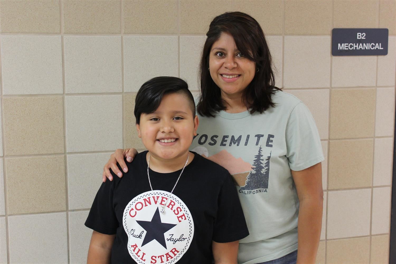 mother and son pose in the hallway